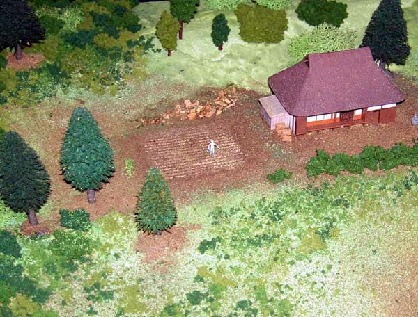茅葺屋根の農家と畑と人形を設置